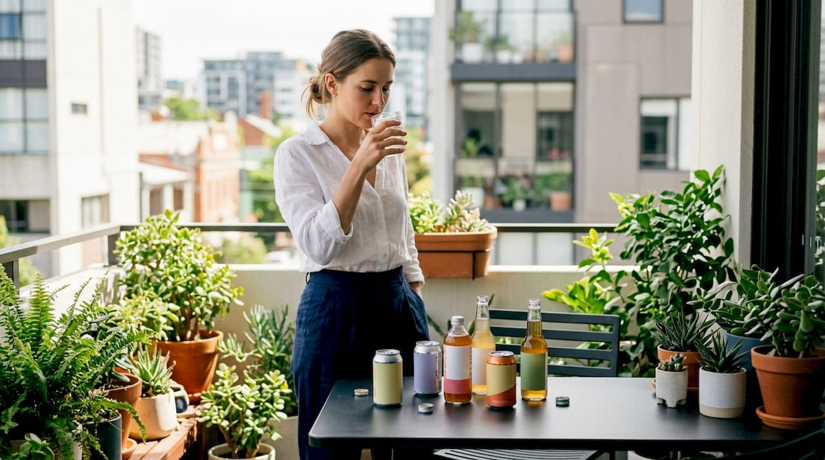 Woman tasting soda alternatives at kitchen counter