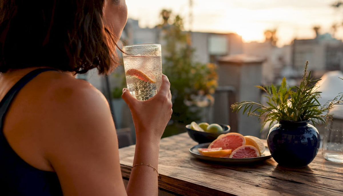 Person holding carbonated drink glass with bubbles