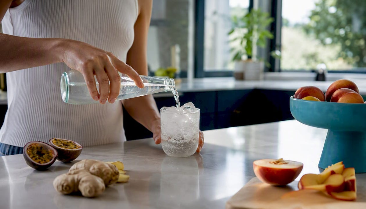 Pouring low-sugar sparkling drink with fresh fruit