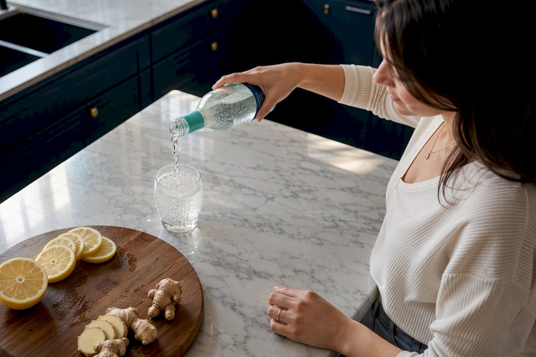 Parent pouring sparkling tonic drink