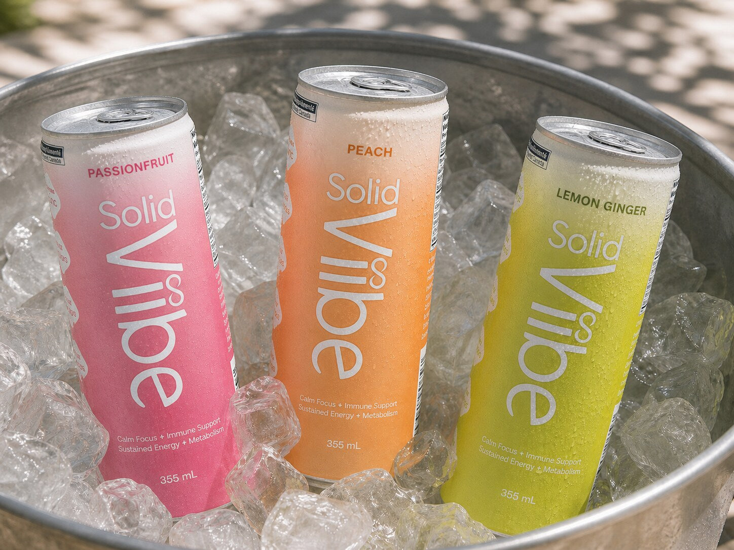 All three Solid Viibe flavours standing chilled in a metal tub of ice in dappled sunlight